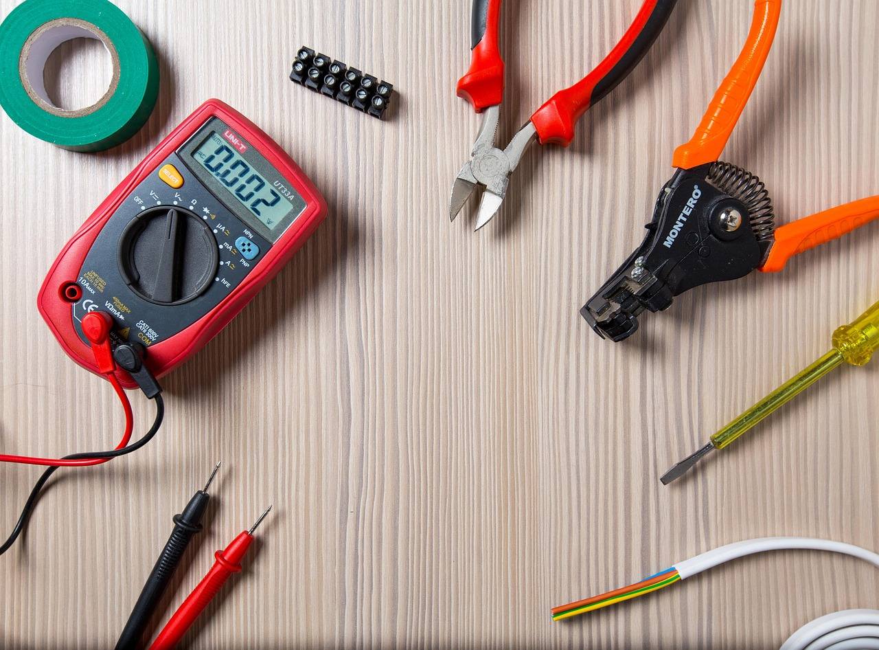 Elektriker-Werkzeug auf der Werkbank: Seitenschneider, Tester, Draht